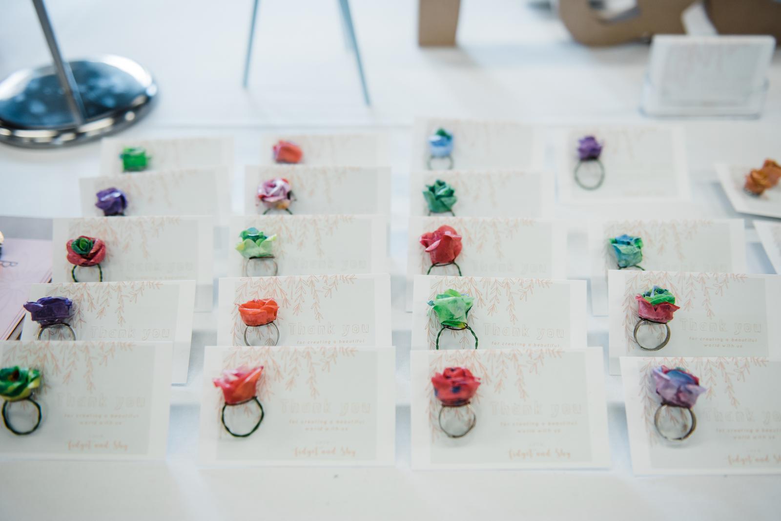 Rows of handmade paper rose rings.
