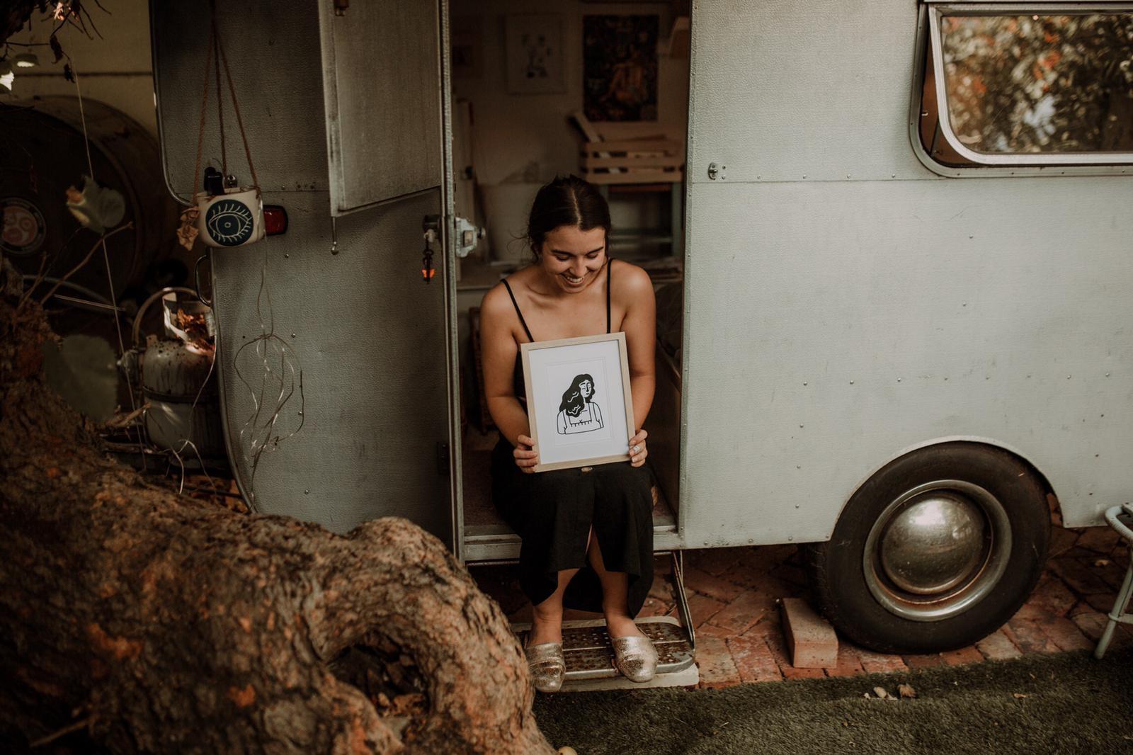 Kikitsa Draws, Outside caravan-studio, Claudia holding“Woman. Me?” Framed Print