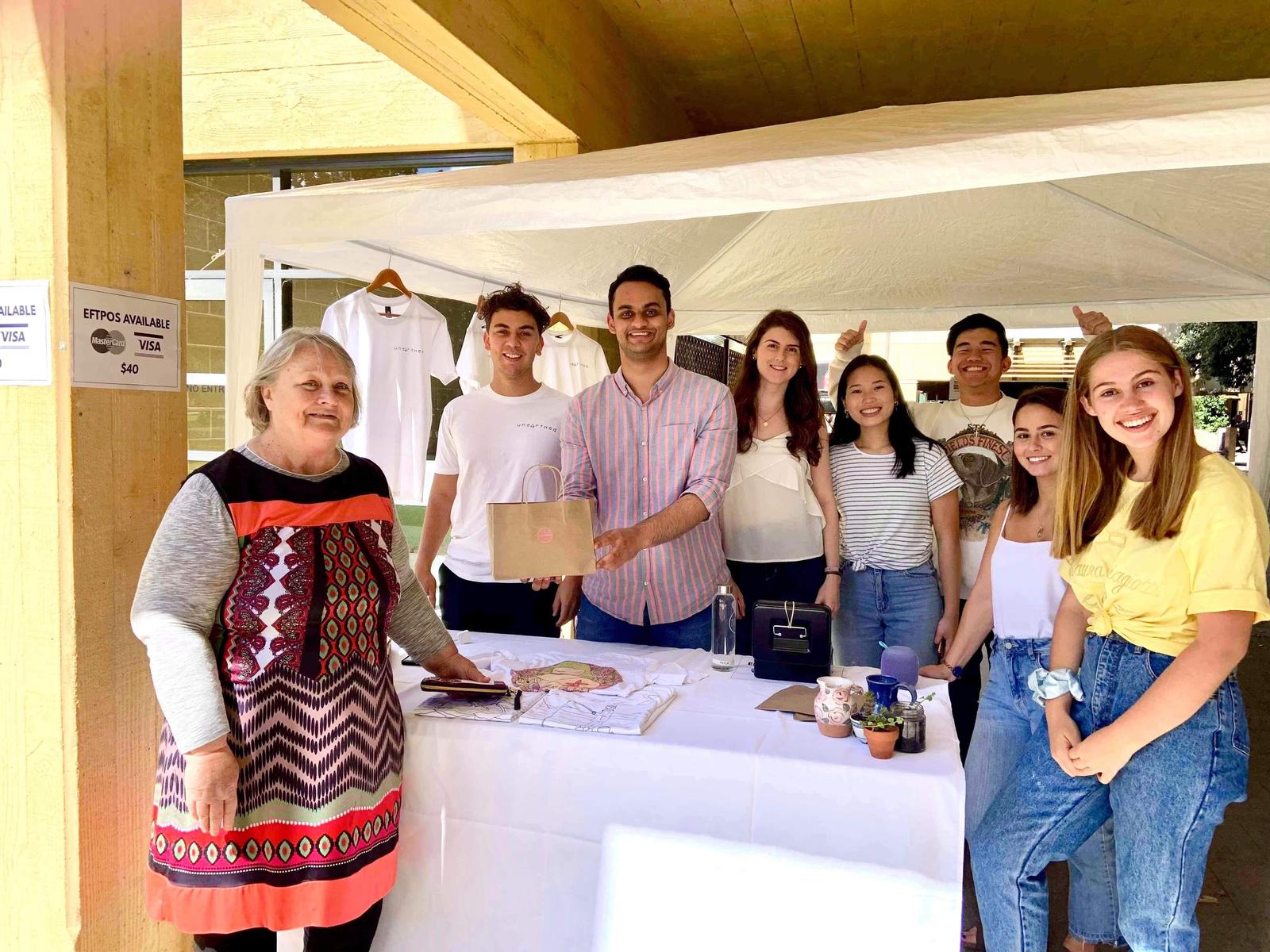 Volunteers with one of the artists at UWA stall